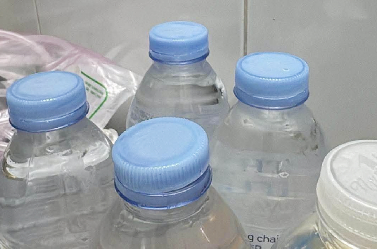 Đổ nước vào chai cũ bán trước cổng bệnh viện