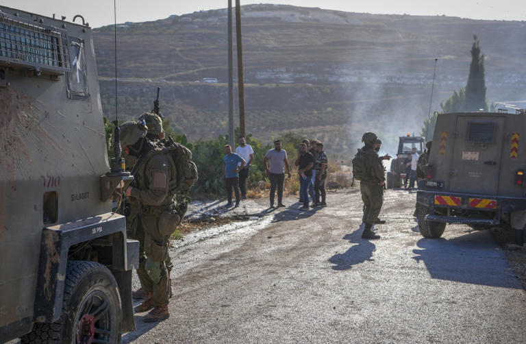 Israeli soldiers inspect the damage following an attack by Israeli settlers in the village of Sarra, near the West Bank city of Nablus, July 24, 2026. (credit: STR)