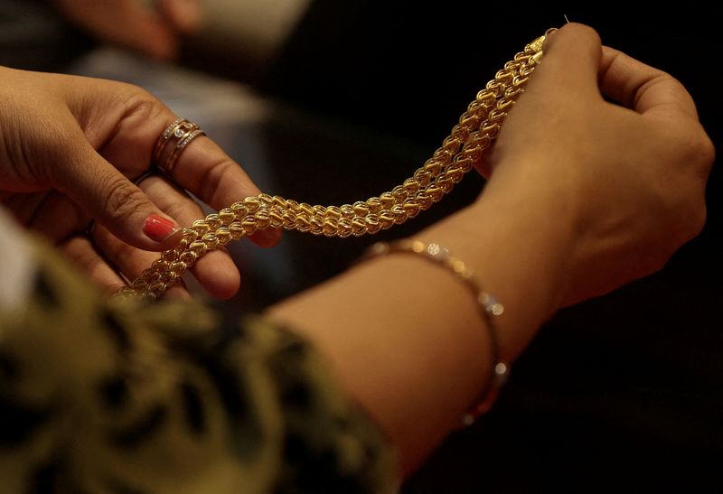 Gold off two-month peak as traders seek inflation cues