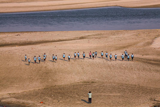 An instructor trains children on a dry patch of the Ganga riverbed. (Photo: PTI)