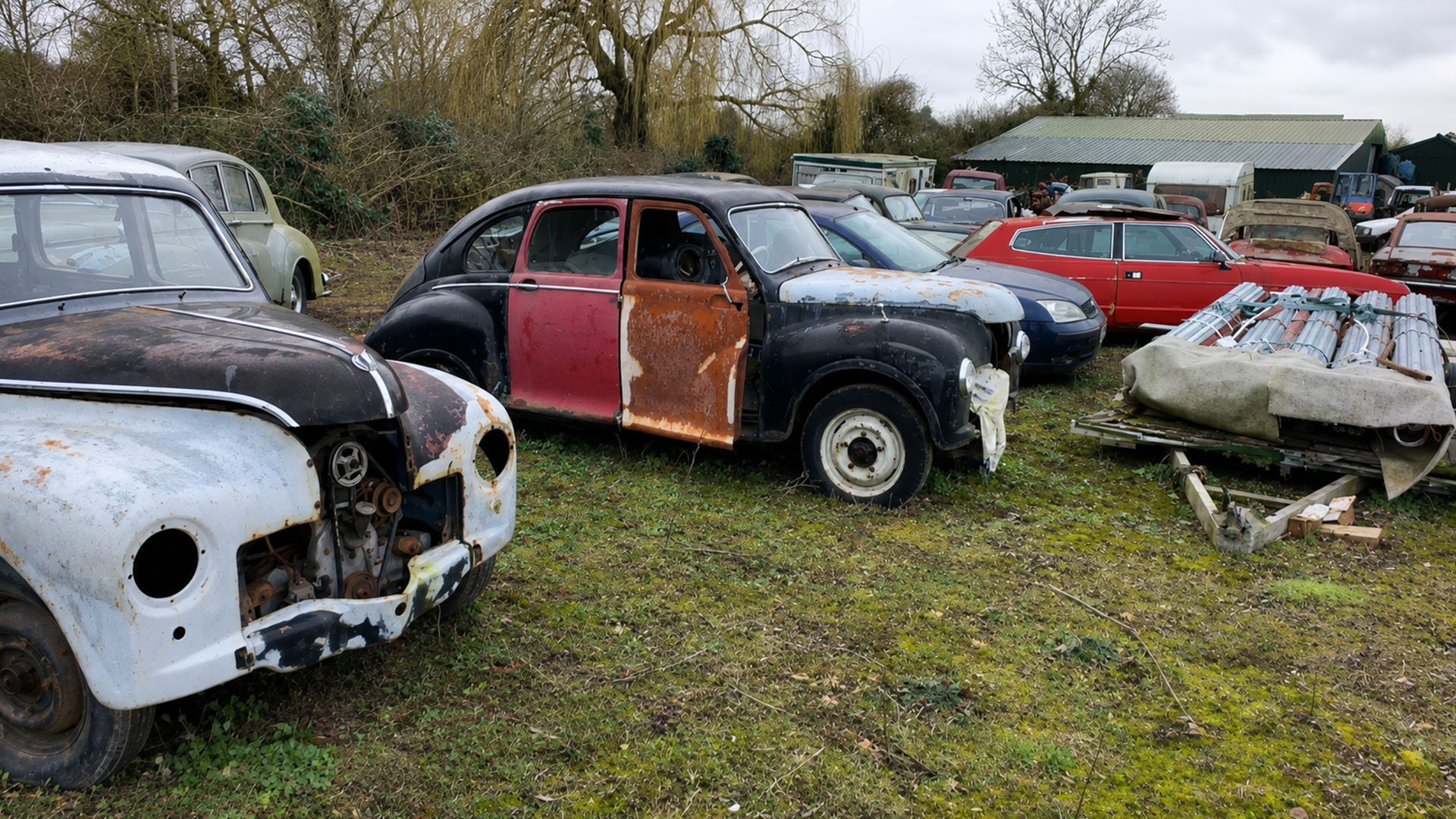 A huge collection of classic cars covered in dust and full of rust