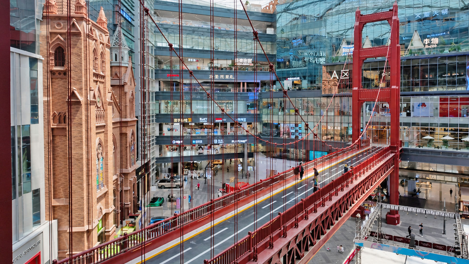 Modern retail atrium showcases iconic red suspension bridge and church ...