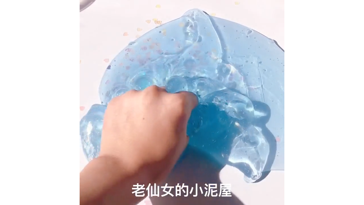 Poking ice blue crystal slime creating glossy bubble pop waves