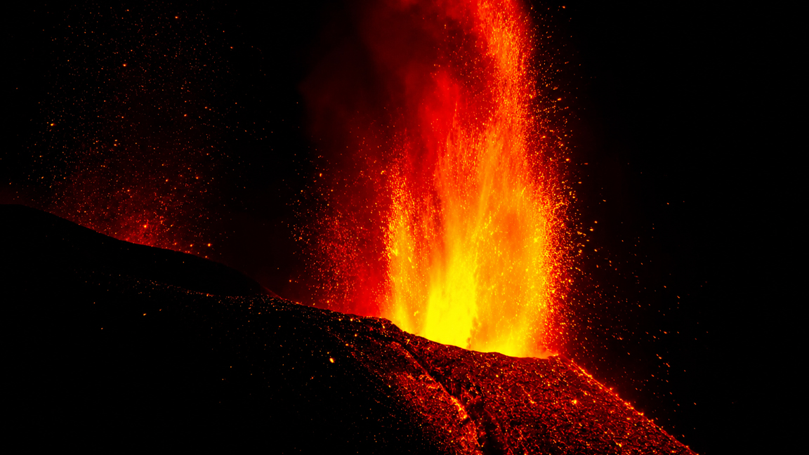 A massive lava fountain erupting into the night sky