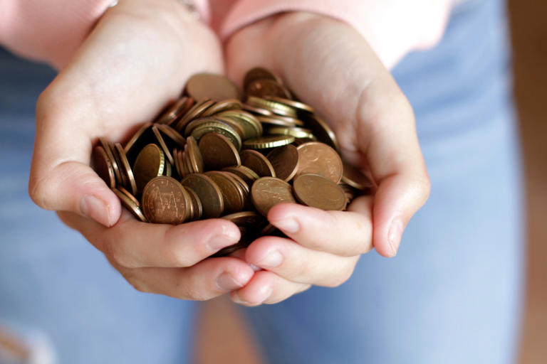 Mujer sosteniendo monedas de euro en las manos