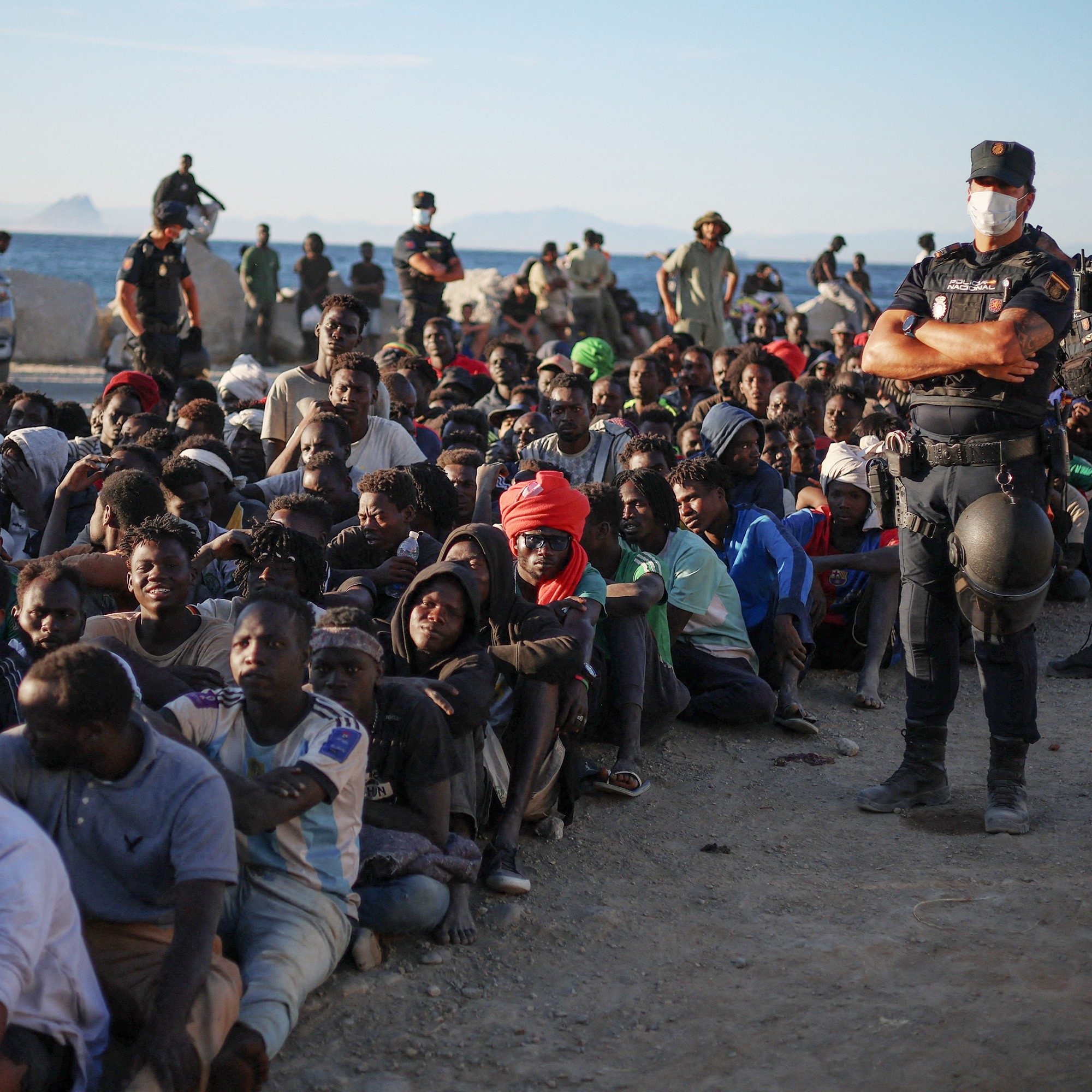 Migrants wait for food and water from the Red Cross following the mass crossings into Ceuta - Pedro Nunes/Reuters