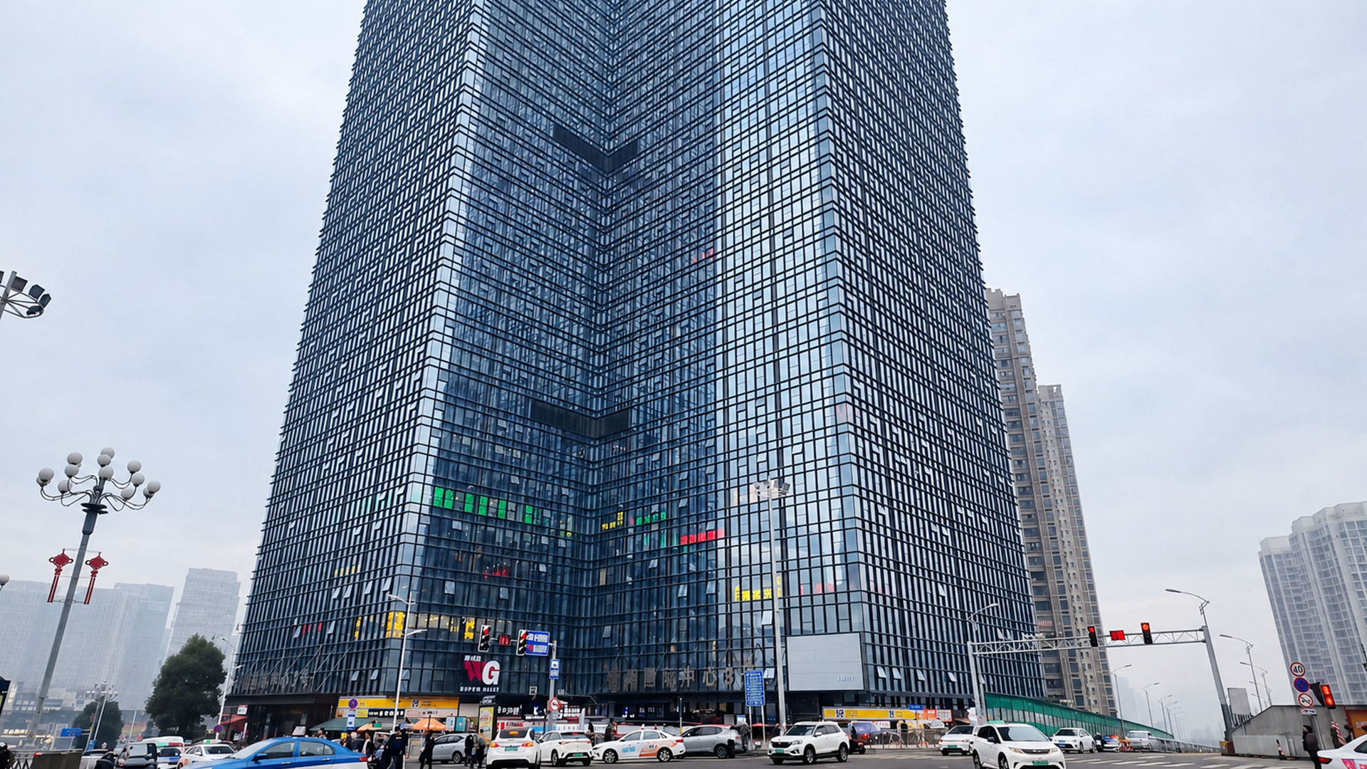 Gedung pencakar langit kaca di China menjulang di atas jalanan yang ...