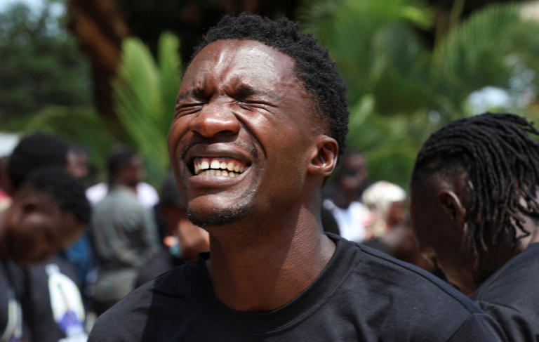 A Ugandan football player mourns the loss of his teammate (Picture: Reuters)