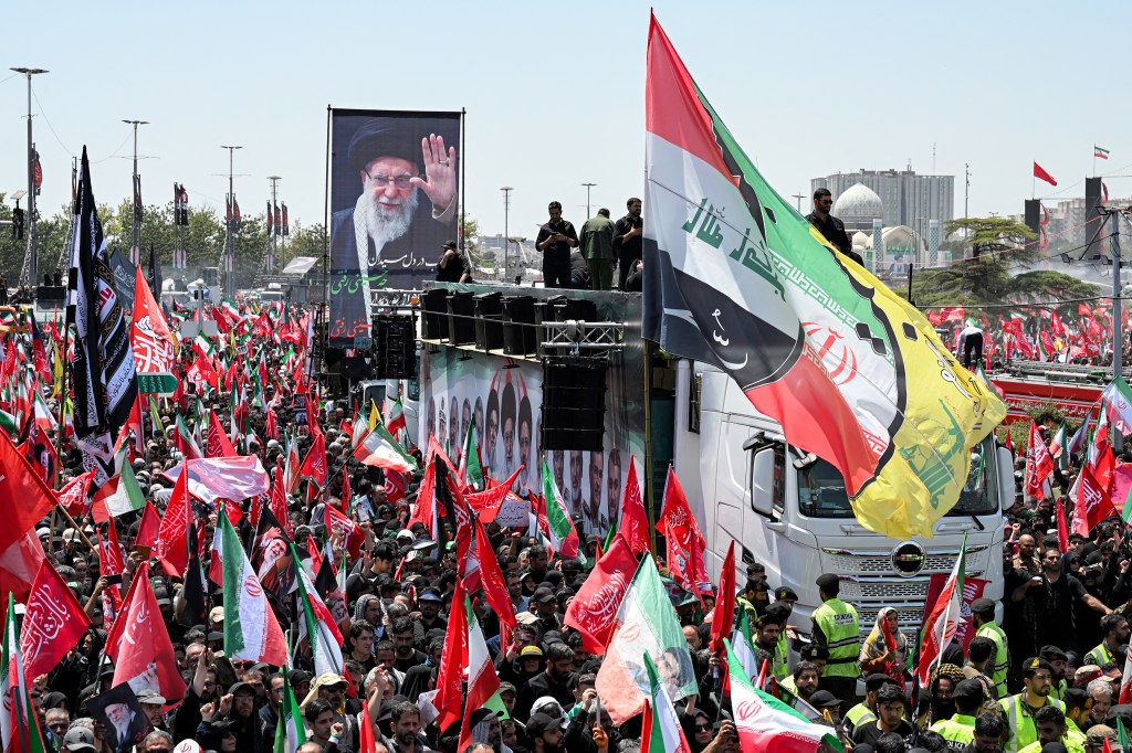 Mourners with the flags of Iran, Iraq, Hezbollah and other Shiite Muslim banners gather during a funeral procession for Iran’s slain Supreme Leader Ayatollah Ali Khamenei at Azadi Square in Tehran on July 6, 2026.