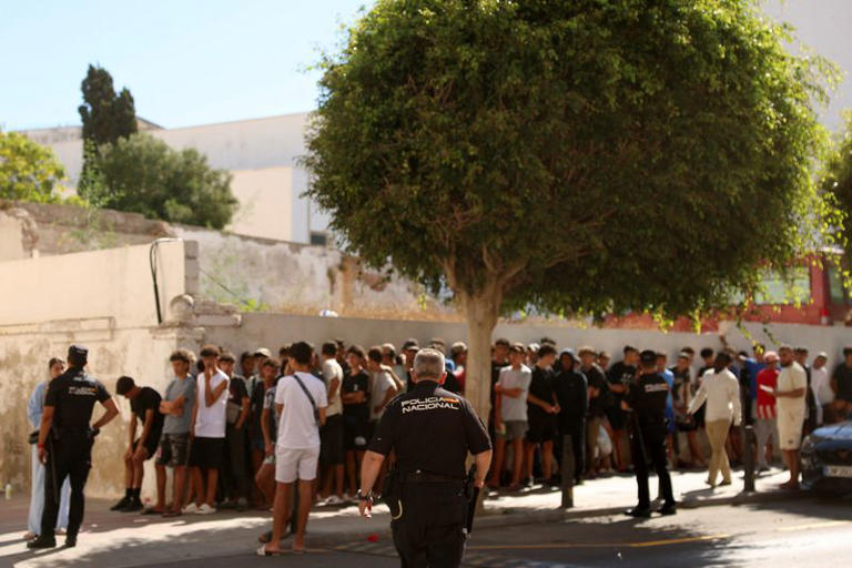 Migrant children queue outside a police station to be registered following mass crossings by migrants on foot and by sea from Morocco into Spanish territory, in Ceuta, Spain, August 6, 2026. REUTERS/Violeta Santos Moura