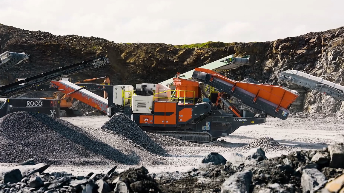 Giant mobile crusher processing mountains of quarry stone