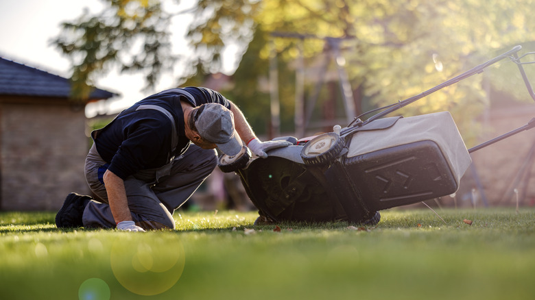 Which way should you tip a lawn mower?