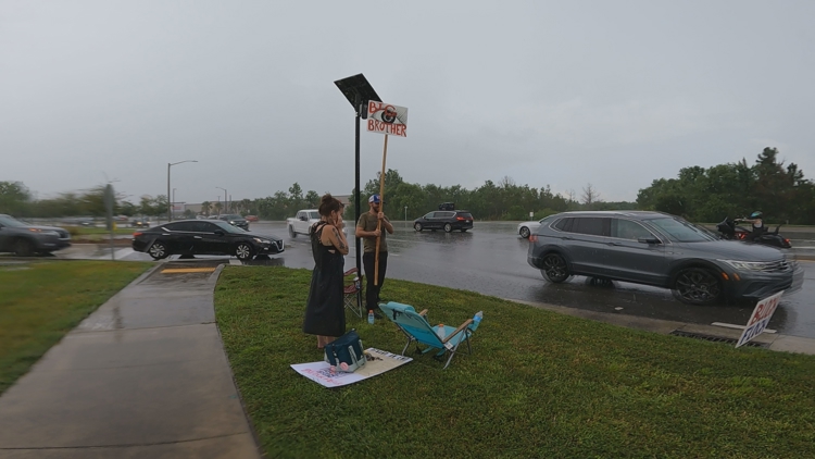 Deflock St. Johns County blocks License Plate Reader with picket signs during protest