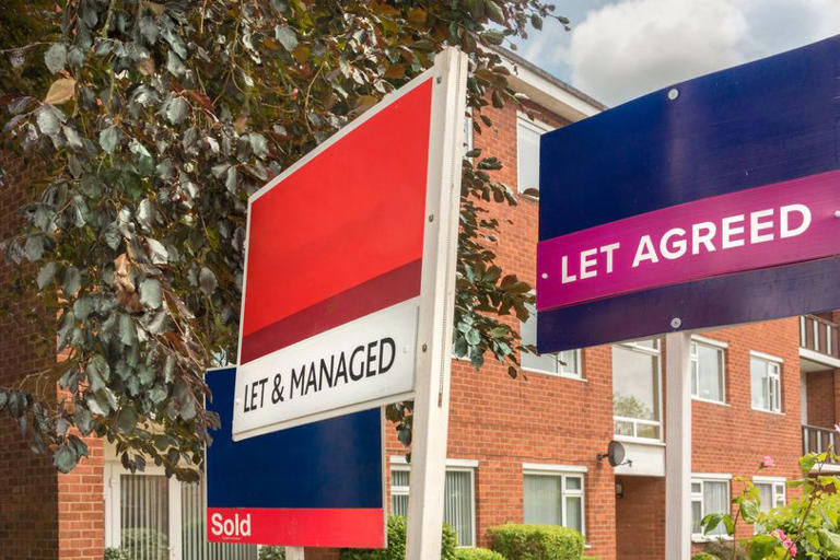 Real estate signs in front of houses at the street. Sold sign, Let agreed sign and Let and Managed sign from estate agencies in front of residential flats building in England. Property market in UK.