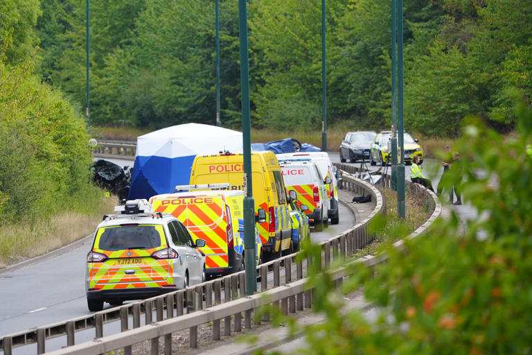 Police officers at the scene of the fatal crash involving a police car and a Volkswagen Passat on the A66 (PA)
