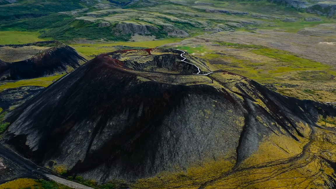 Ancient volcanic crater rising above a vast green landscape