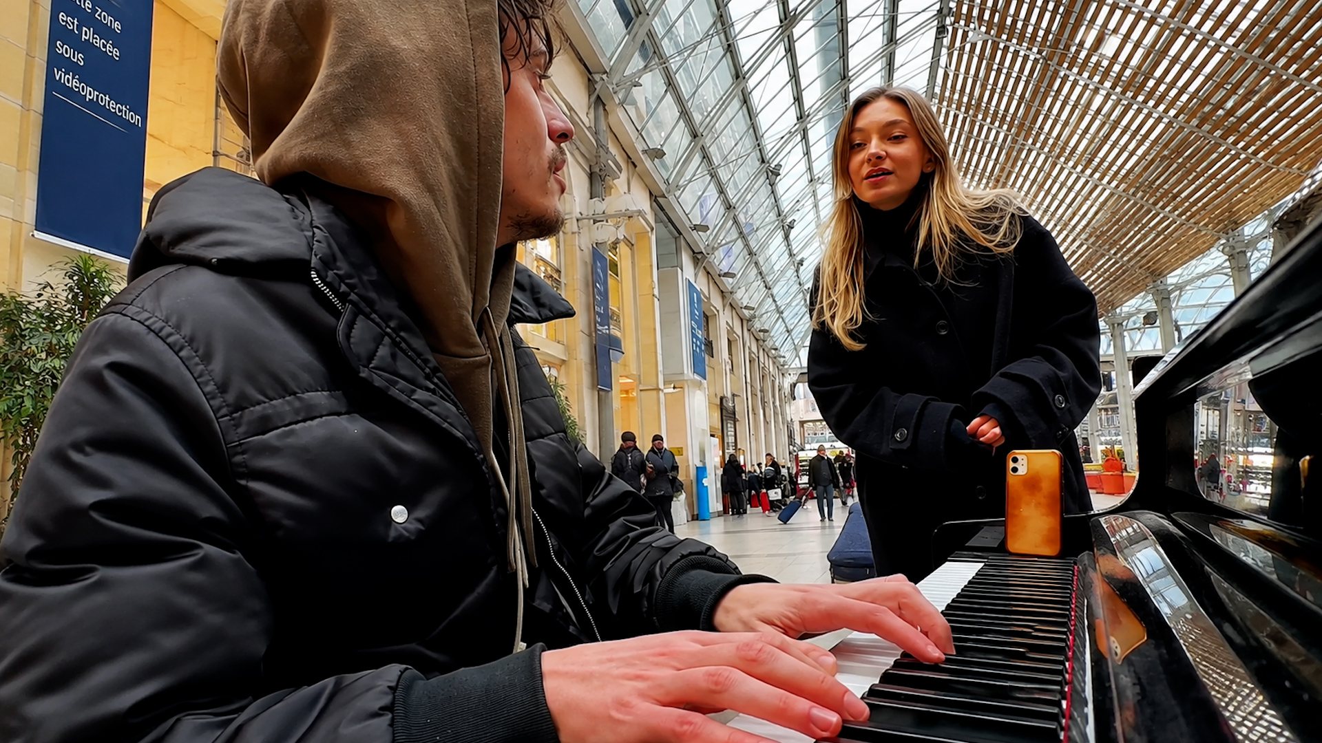 People gather around a train station piano for Bob Marley’s hit