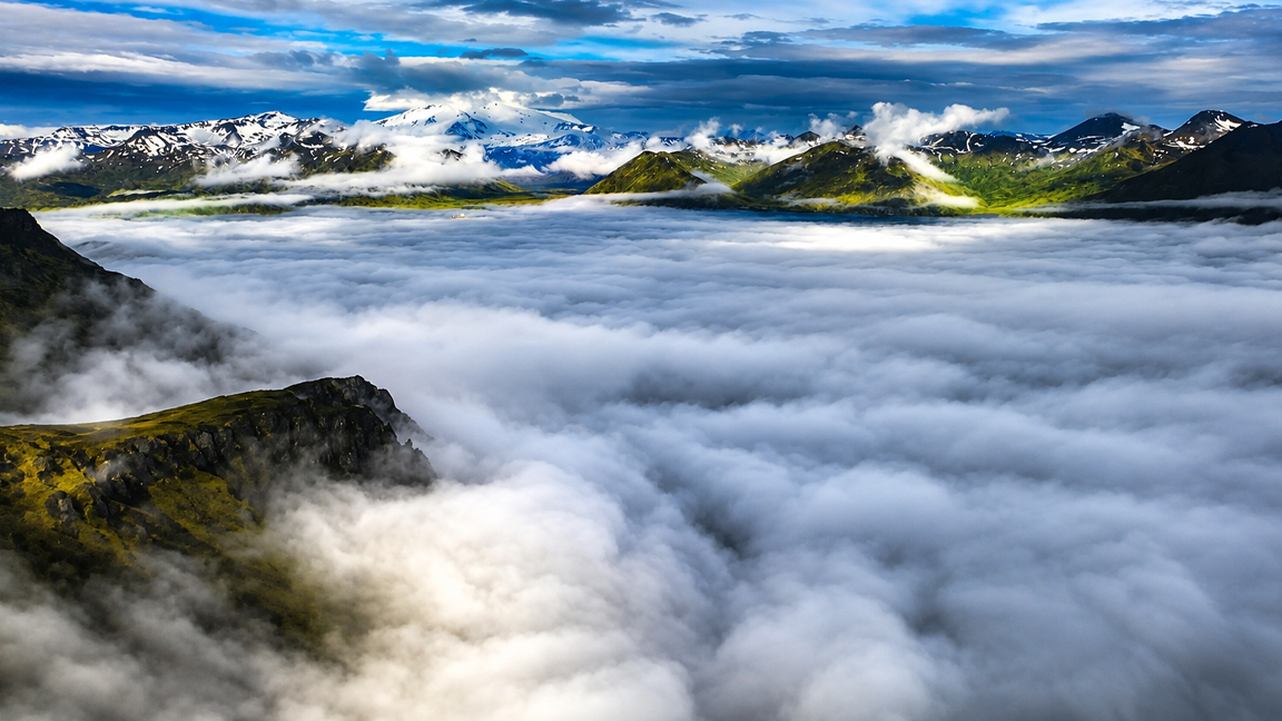 mountain-peaks-emerging-above-a-vast-blanket-of-clouds