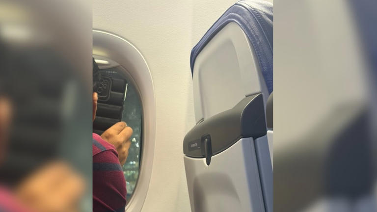 passenger-shows-plane-window-view-to-family-on-video-call-their