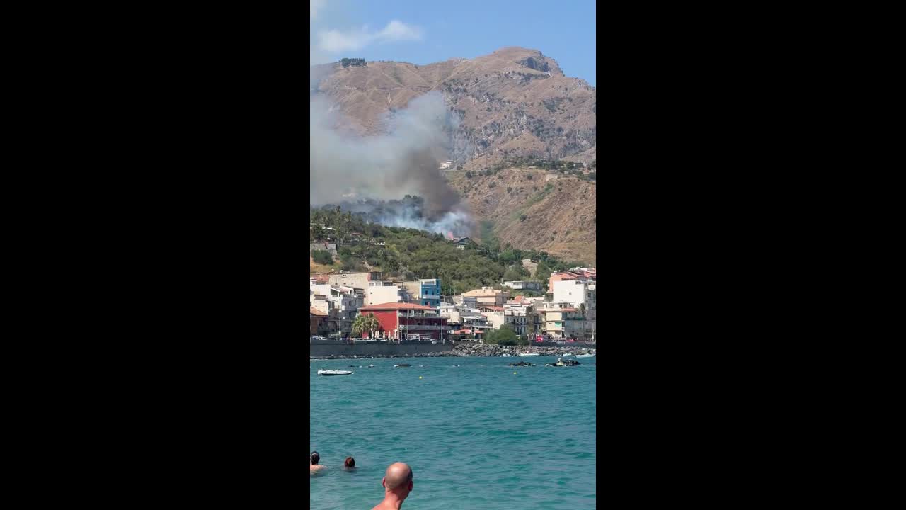 Wind-driven wildfire burns near homes in Giardini Naxos, Sicily, Italy