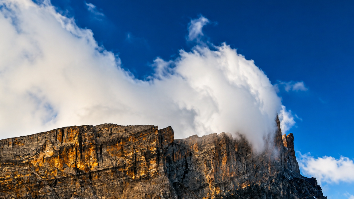 Towering rocky cliffs disappearing into the clouds