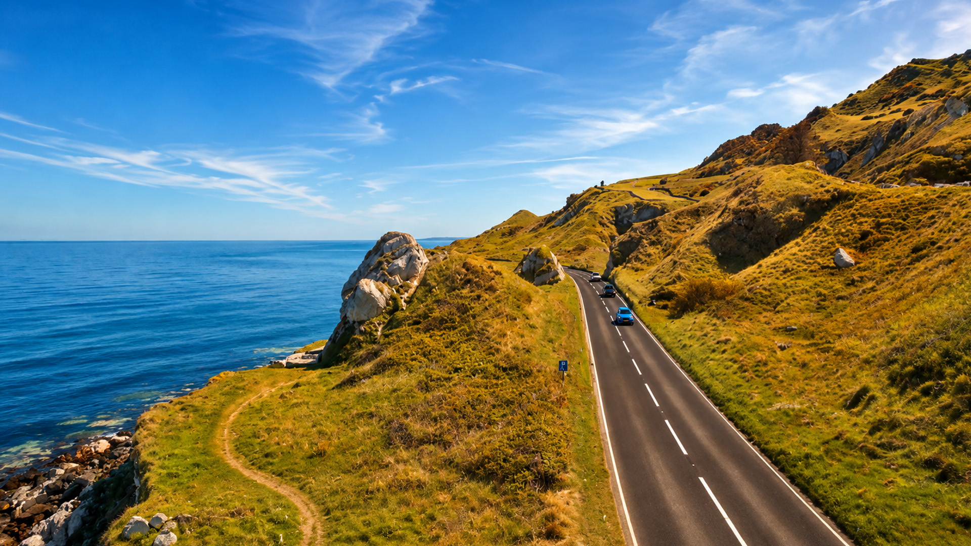 A winding road between Northern Ireland’s green hills and the sea