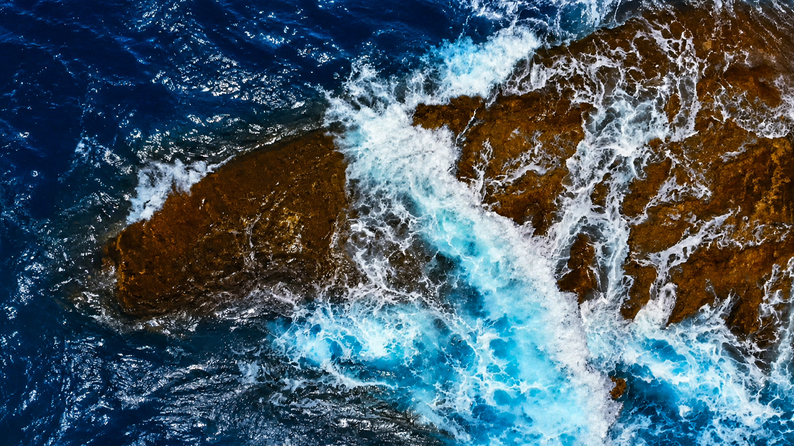 Powerful ocean waves crash across a rocky shore