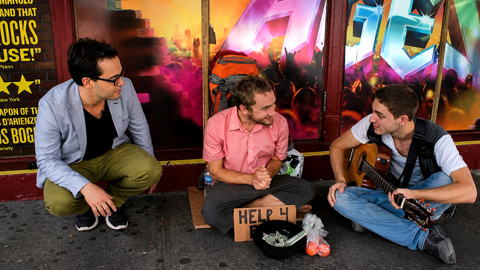 Street musicians help a homeless man in New York