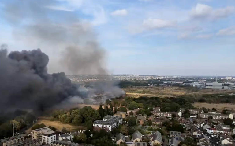 Large plumes of smoke rising from the blaze - X