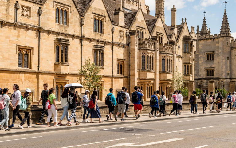 Students and tourists walking past Magdalen College Oxford