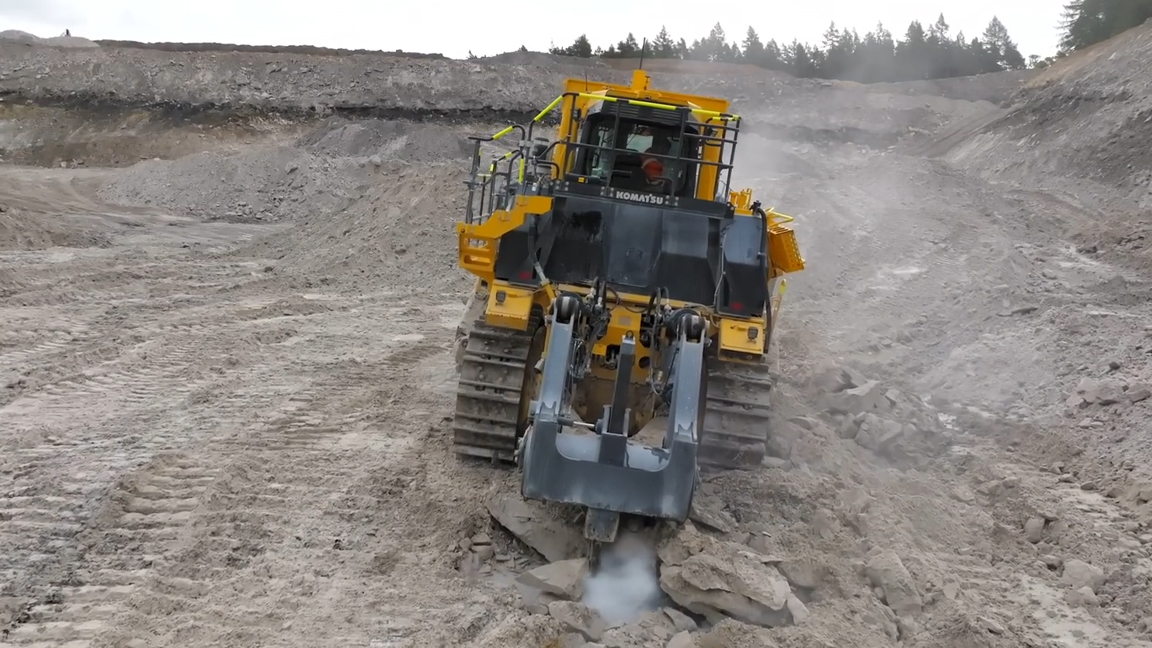 Massive Komatsu dozer ripping solid rock with extreme power