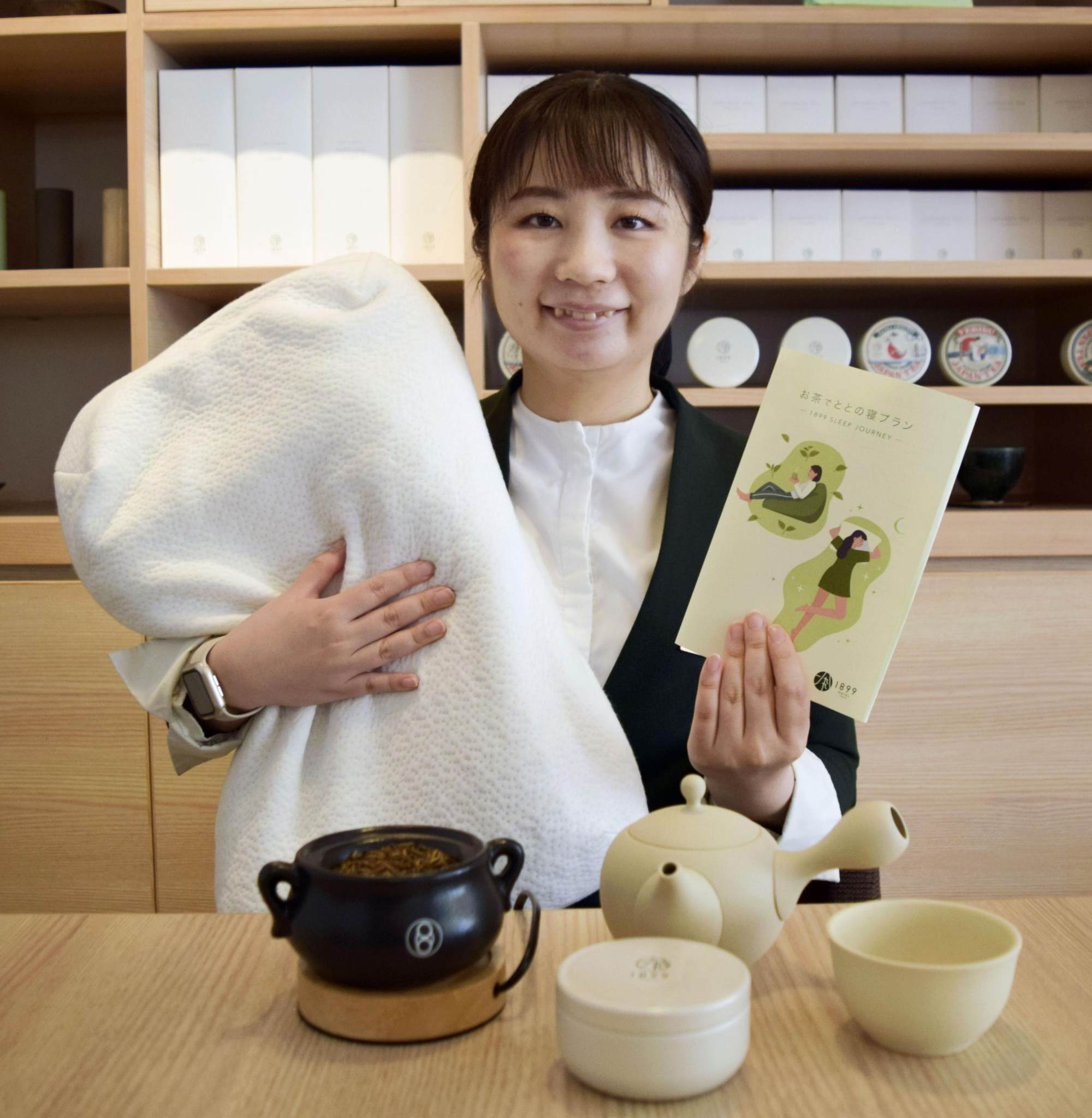 Hotel 1899 Tokyo's Yuiko Ogawa holds a leaflet and a high-performance pillow used for its totono-ne sleep plan in Tokyo in July. Photo: Kyodo