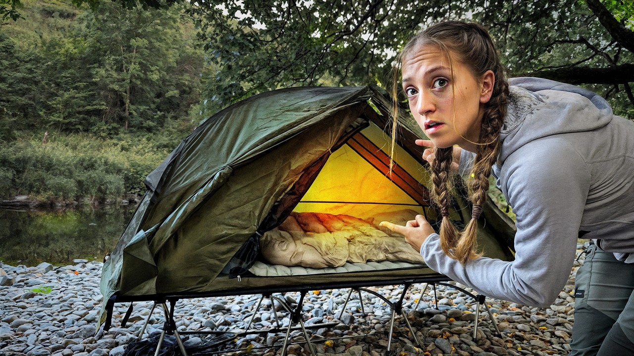 Camping in a tiny raised tent by a river