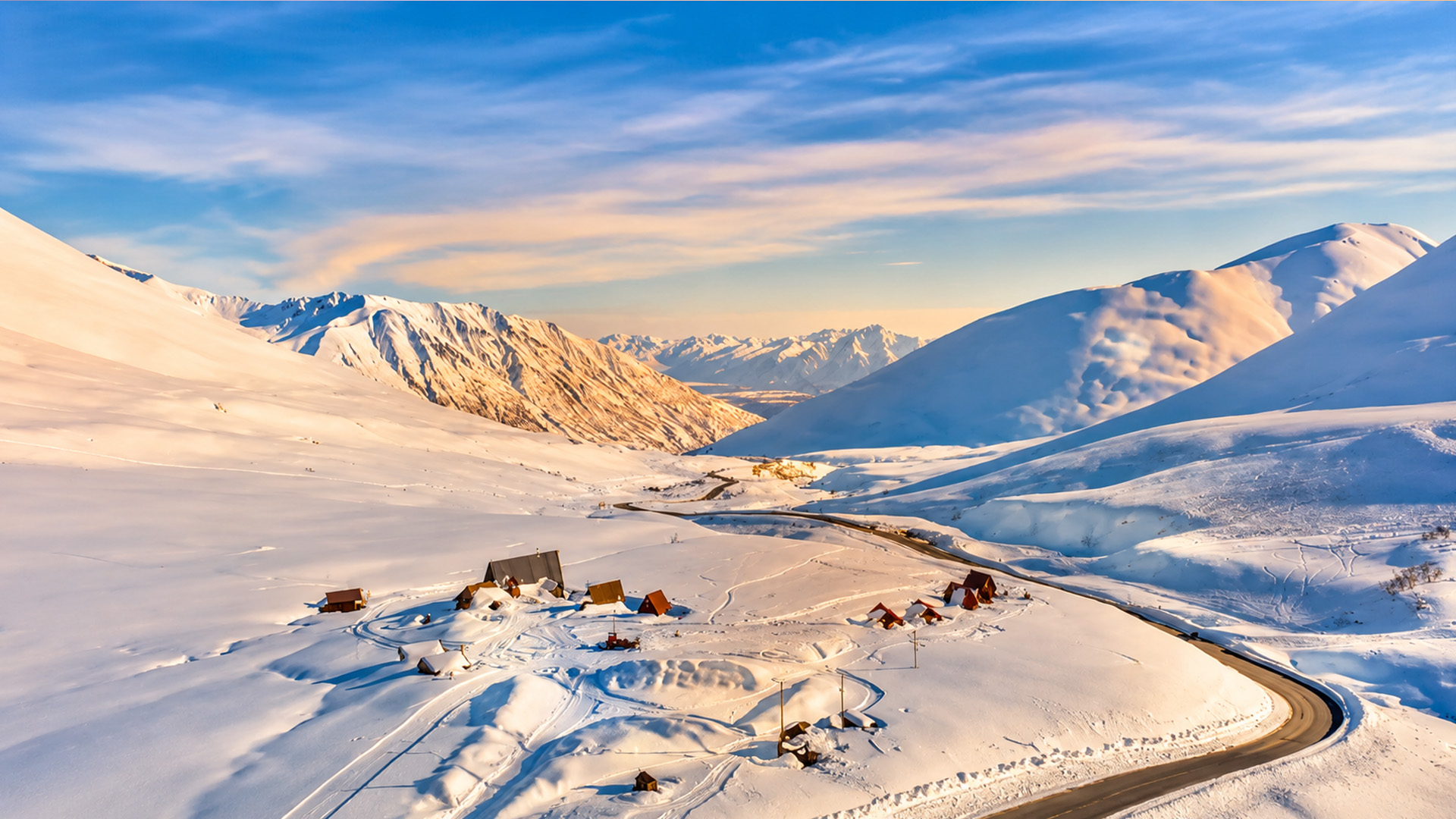 A snow-covered road winding through Alaska’s mountain wilderness