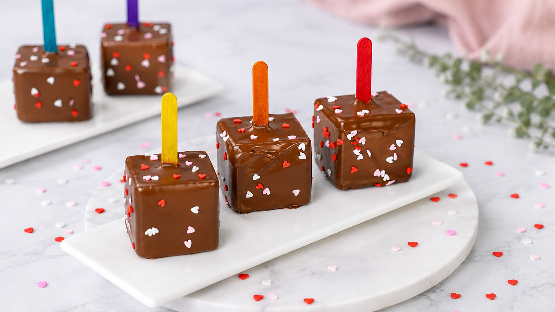 Colorful mousse cubes dipped in chocolate