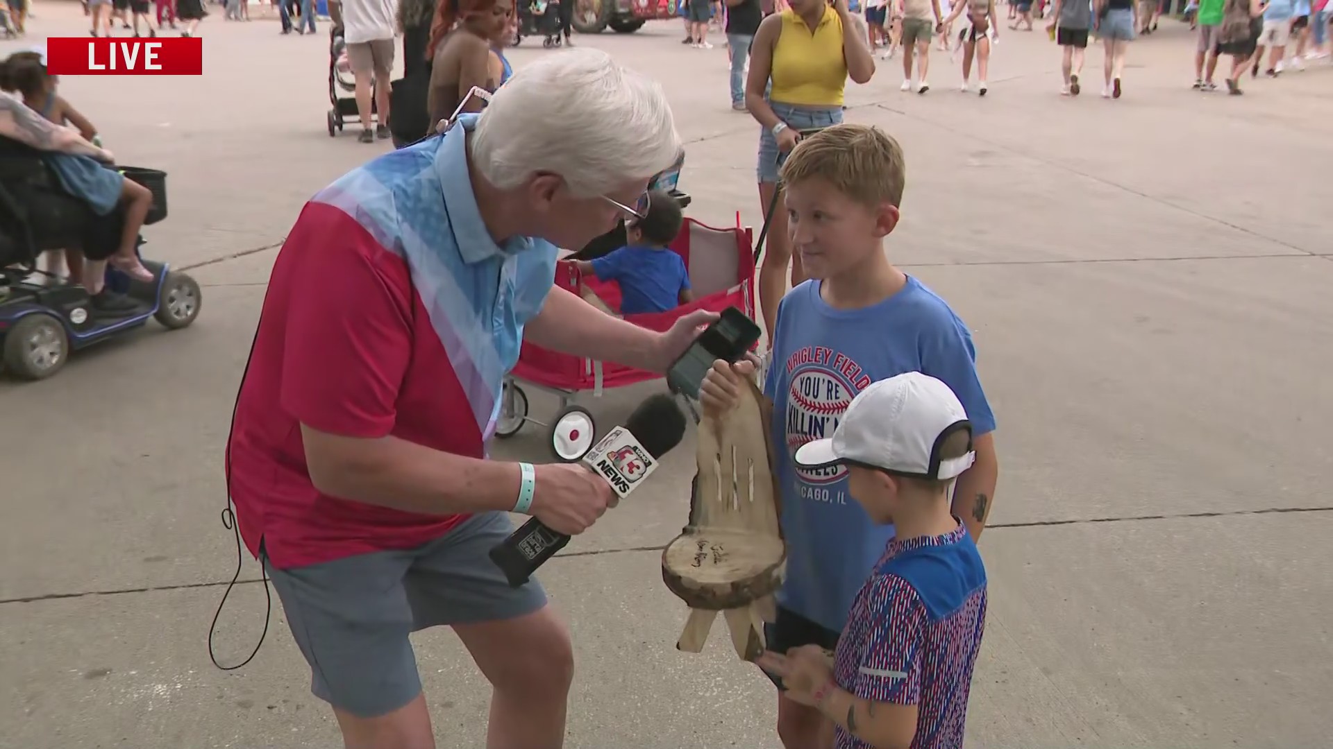 Ed Wilson talks to 2 brothers who show off lumberjack-made gift