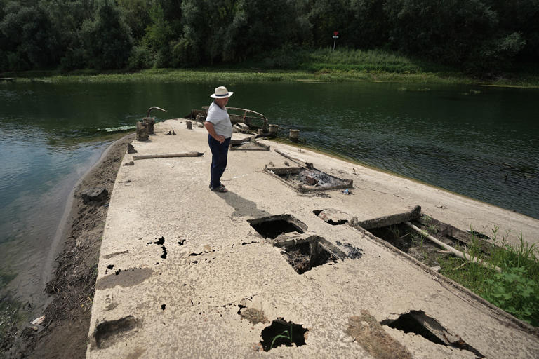 Stanislav Kozenko stands on the wreckage of the old steam boat (AP)