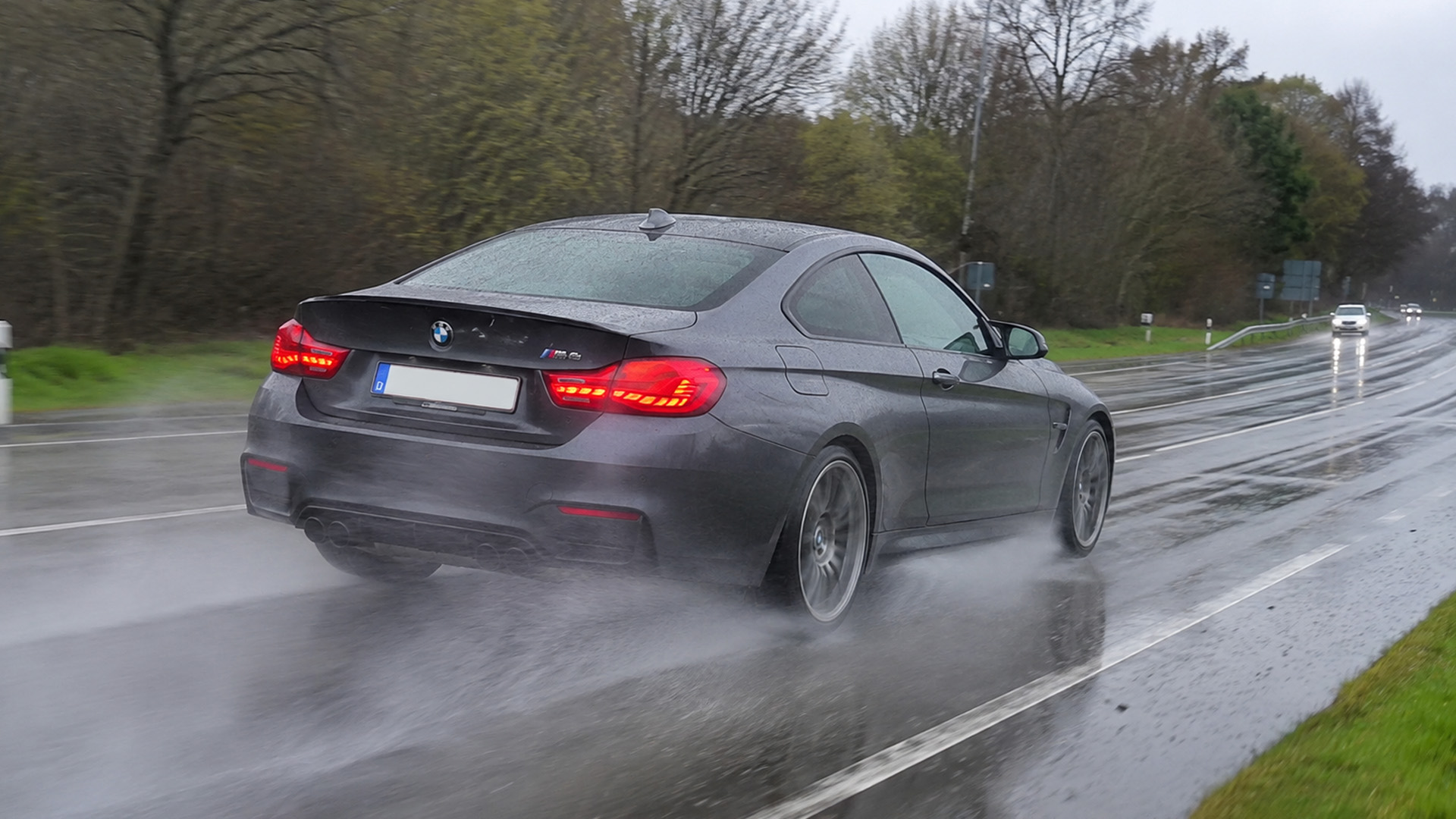 bmw-m4-competition-rijdt-over-natte-regenachtige-wegen
