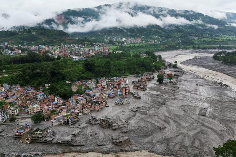 Houses lie partially submerged in muddy water along a riverside after flash floods at Trishuli Bazar in Nepal's Nuwakot district on Wednesday. (AFP)
