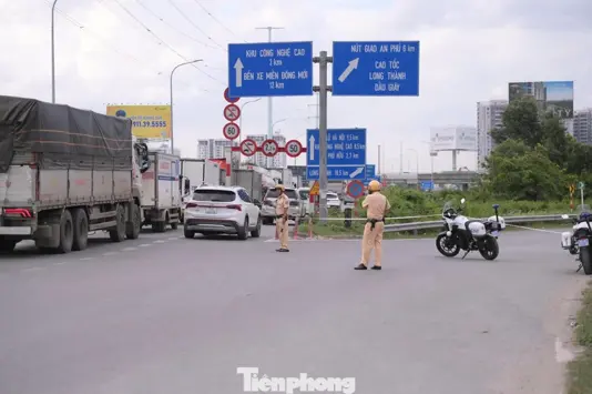 Báo điện tử Tiền Phong CSGT Đội Cát Lái điều tiết phương tiện tại khu vực vòng xoay Phú Hữu nhằm giảm áp lực lên cao tốc. Ảnh: Nguyễn Tiến 1