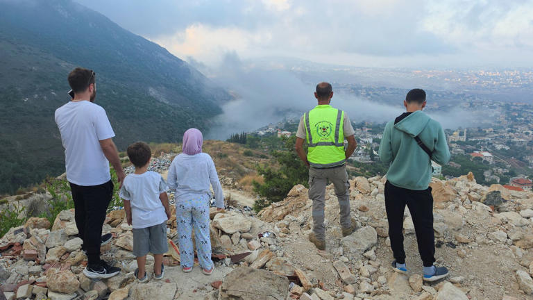 People watch smoke rising in Arab Salim. Pic: Reuters
