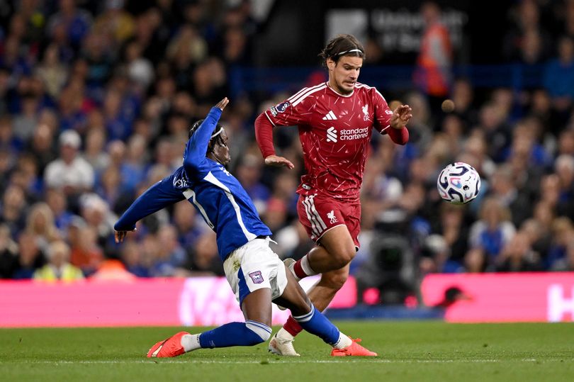Milos Kerkez of Liverpool is challenged by Abdul Fatawu of Ipswich.
