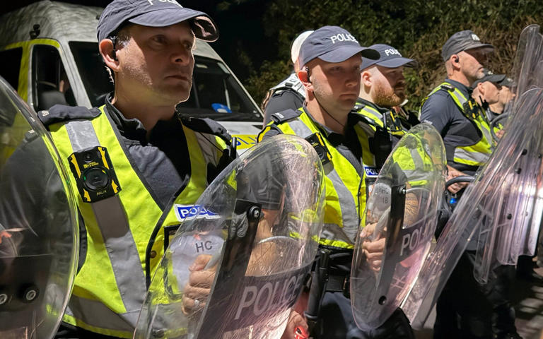 Police officers with riot shields form a line at the protest at a marina in Eastney, Portsmouth - Eddie Mitchell