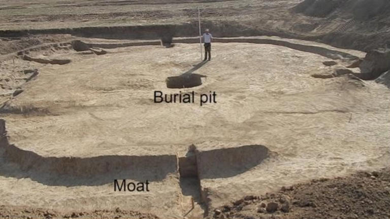 Vista aérea del túmulo escita excavado en Novozavedennoye-III (sur de Rusia), con la fosa de enterramiento ("burial pit") en el centro y el foso perimetral ("moat") que la rodea. Fuente: Spasskaya et al., Journal of Archaeological Science: Reports (2026).