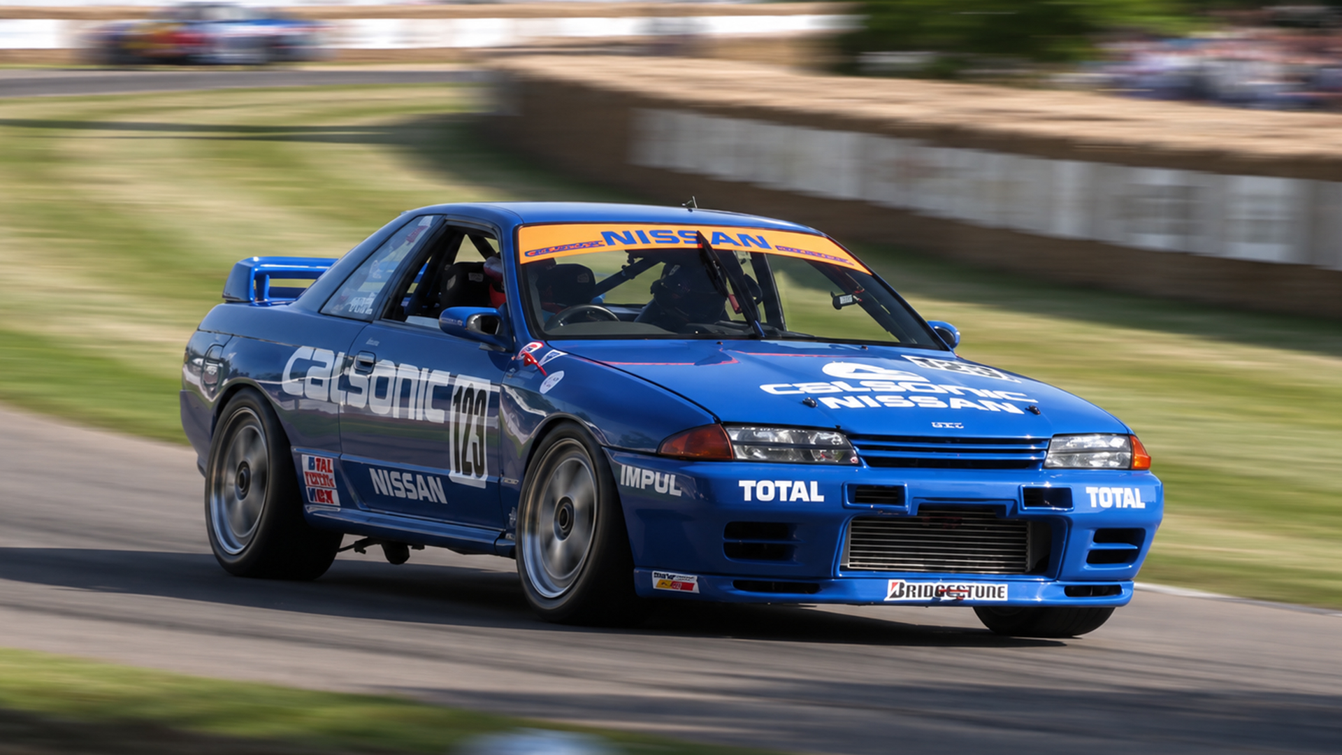 Nissan Skyline GT-R R32 attacks a hillside corner in race livery