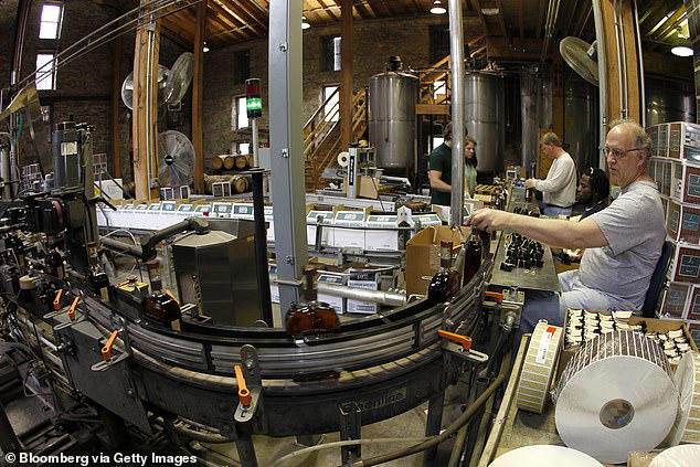 Workers label bottles of Woodford Reserve bourbon whiskey, a Brown-Forman Corporation brand, on the bottling line at the company's distillery in Versailles, Kentucky
