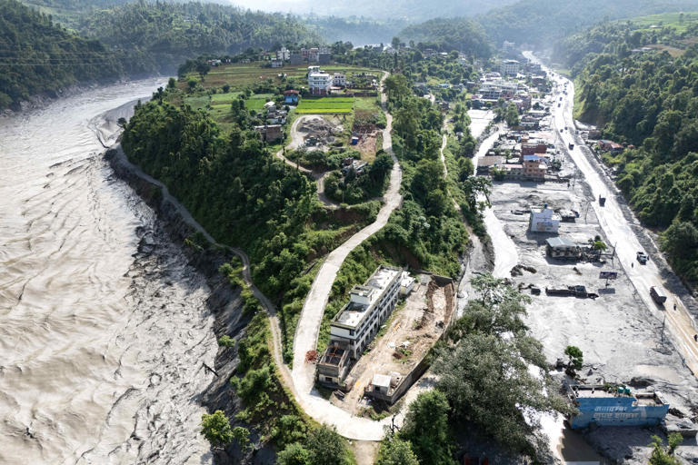 This aerial photograph shows an overflowing Trishuli River (L) and houses covered in mud (R) in the aftermath of flash floods at Baireni in Nepal's Dhading district (AFP/Getty)