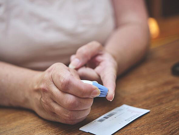 A woman doing a finger prick test at home