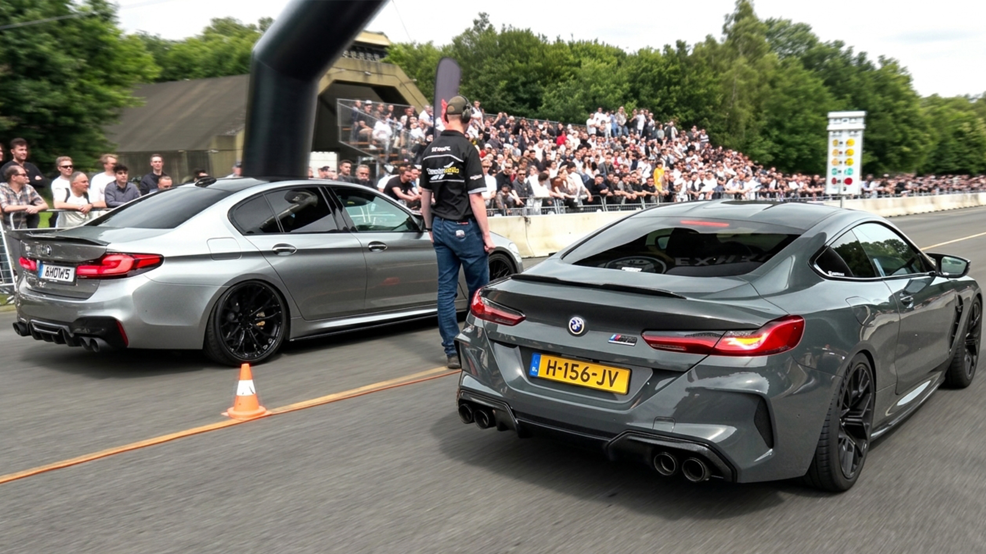 BMW M8 stages beside a BMW M5 for a drag run