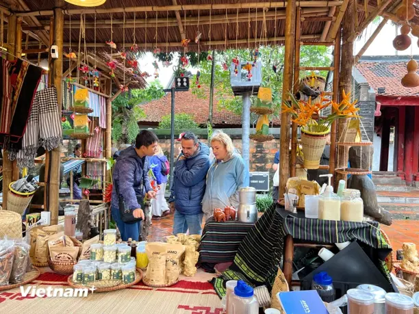 Du khách quốc tế tham quan gian hàng giới thiệu đặc sản vùng miền trong khuôn viên Văn Miếu-Quốc Tử Giám. (Ảnh: Xuân Mai/Vietnam+)
